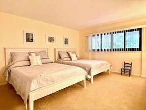 A bedroom with two beds, a window with blinds, and a chair. - Pristine Gulf Beachfront Longboat Key (Longboat Key)