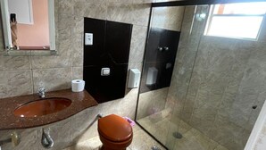 Une salle de bain avec un sol en marbre, un lavabo, des toilettes et une cabine de douche en verre.