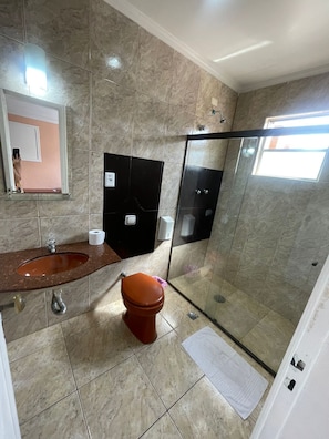 A bathroom with a marble floor, a sink, a toilet, and a glass shower enclosure. - Hotel Vitória de Santos (Santos)