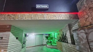 Un couloir, à l’extrémité duquel se trouve une pancarte indiquant « ENTRADA », mène à une pièce dotée d’un mur en pierre et d’une plante.