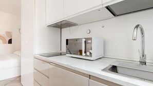A modern kitchen with a built-in microwave, a stainless steel sink, and a sleek countertop. - GuestHost - A comfortable 30 square meters studio, perfect for two people, located on the first floor of a building with an elevator (NOT suitable for people with reduced mobility).The apartment is just steps from Pasteur metro station and within a 10-mi (Milan)