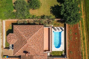 Ein Luftbild eines Anwesens mit Schwimmbad, Terrasse und Garten.