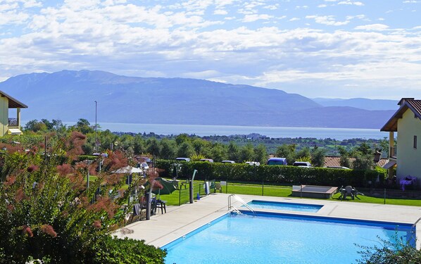 A swimming pool with a view of mountains and a lake. - Appartamento Borgo Alto (Puegnago del Garda)
