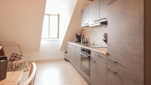 Et moderne køkken med ovenlys, træbjælker og rustfrie stålgadgetter.