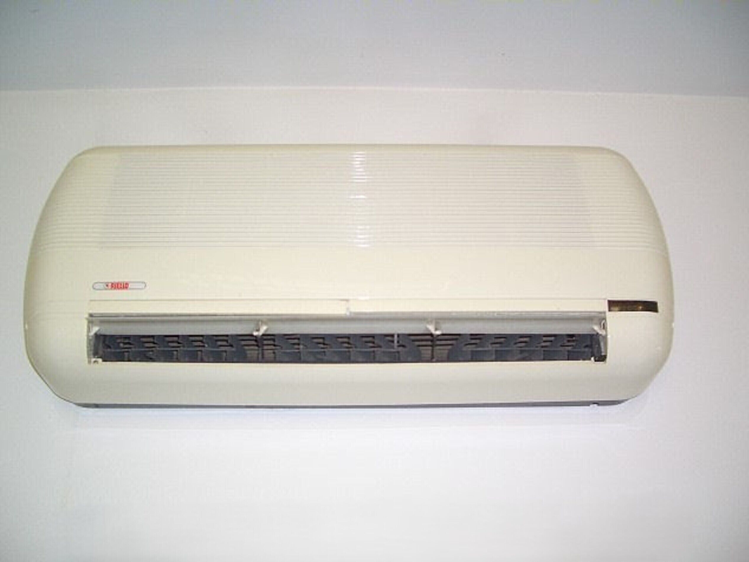 A white, wall-mounted air conditioning unit with a control panel and a digital display.
