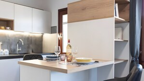Una cocina compacta con una isla central, un lavamanos empotrado y una silla.