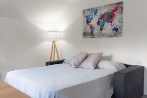 Een slaapkamer met een bed, een lamp en een wereldkaart schilderij.