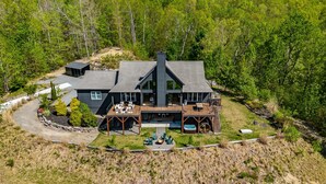 Une grande maison moderne dotée d’une terrasse et d’un espace salon extérieur.