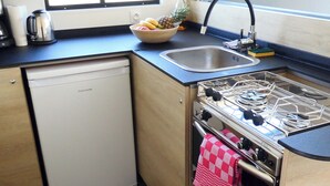 A compact kitchen with a dishwasher, a gas stove, and a sink.