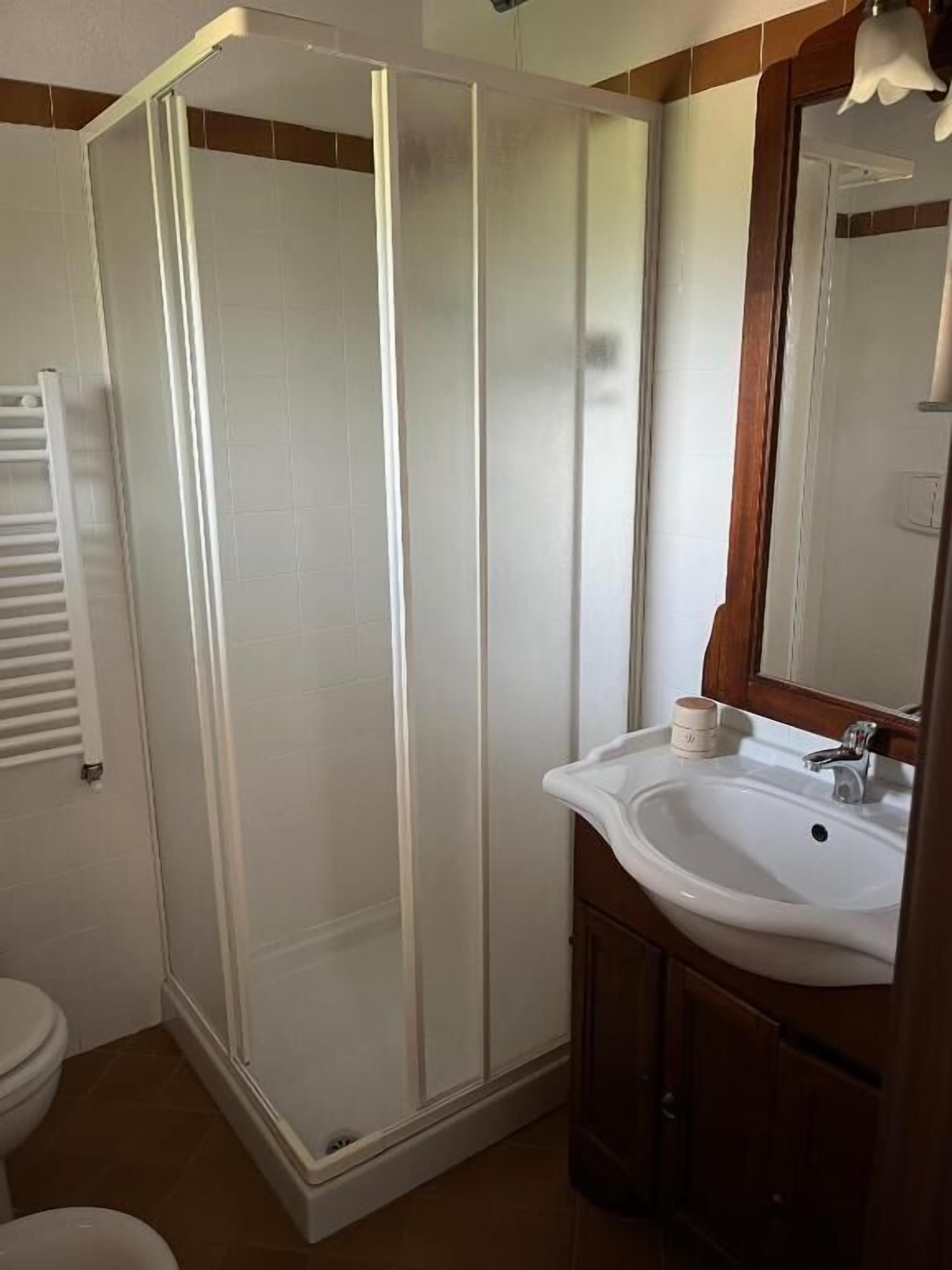 Une salle de bain équipée d’une douche, d’un lavabo et de toilettes.