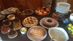 Een buffet met diverse gerechten, zoals brood, gebak en toevoegingen.