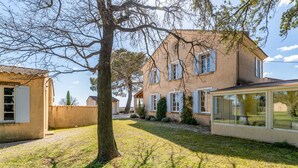 A house with a large tree in the front yard, a glass conservatory, and a traditional architectural style. - Château Mazane – Mas in the Heart of Vineyards, Pool and Mountain View (Sarrians)