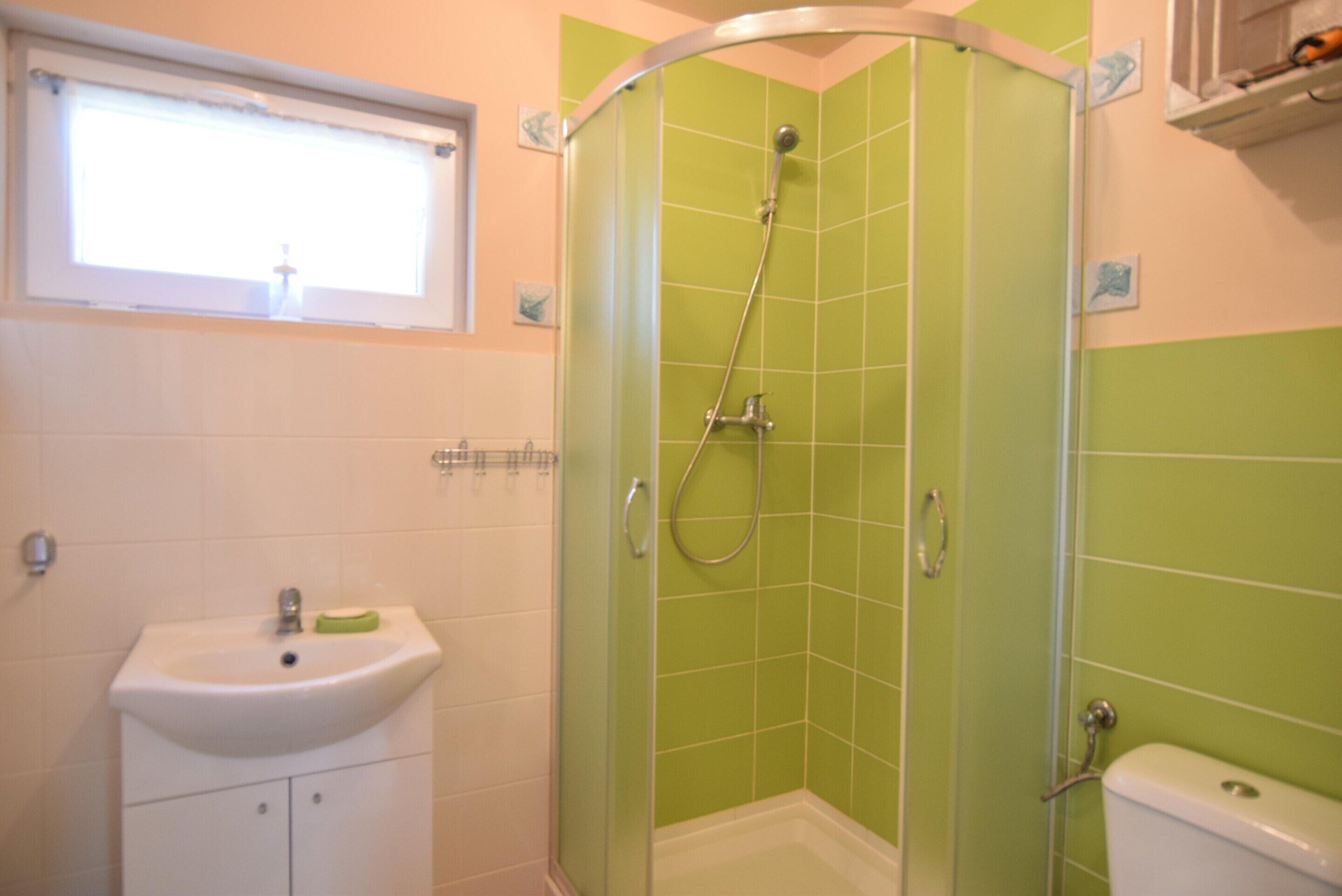 A bathroom with a shower, sink, and toilet.