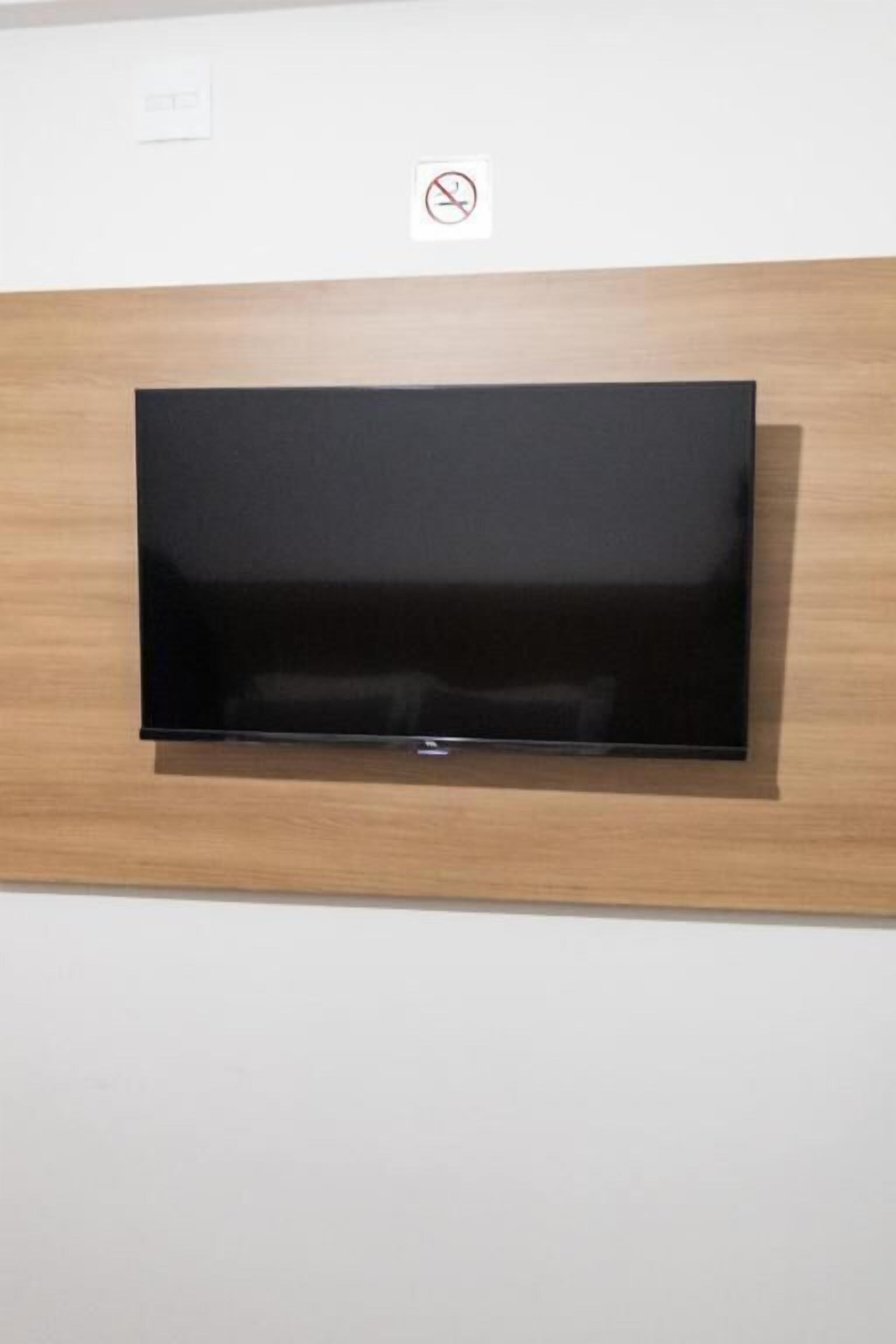 Een flatscreen televisie bevestigd aan een houten muur.