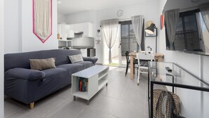 Ein modernes Wohnzimmer mit einer Couch, einem Couchtisch und einem Essbereich mit Tisch und Stühlen.
