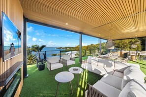 An outdoor patio with a wooden ceiling, white sofas, and a view of the sea. - Beautiful Key Largo Home sleeps 10 (Key Largo)