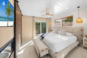 A spacious bedroom with a large bed, a ceiling fan, and a view of the beach through a sliding door. - Beautiful Key Largo Home sleeps 10 (Key Largo)