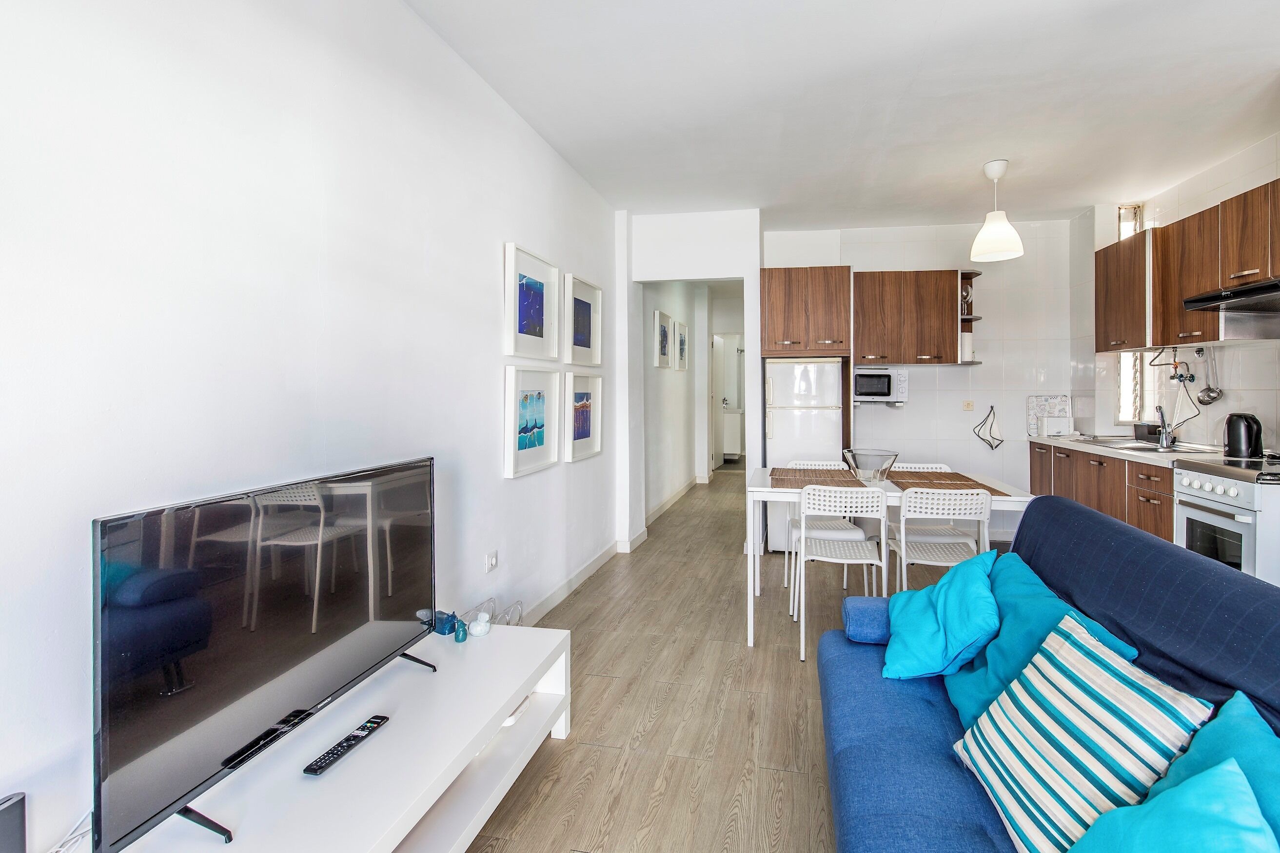 A modern apartment with a living room, dining area, and kitchen.