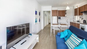 A modern apartment with a living room, dining area, and kitchen. - Sunny Apartment with Terrace in El Médano (El Medano)
