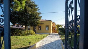 Una casa amarilla con un camino de baldosas que lleva a la entrada.