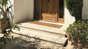 Un bâtiment traditionnel avec une porte en bois et des marches menant à l’entrée.
