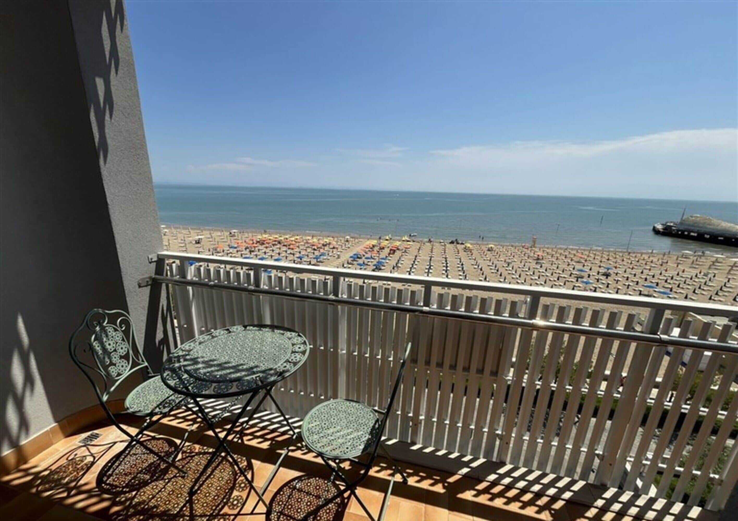 Un balcón con vista a una playa y al mar.