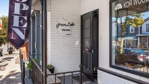 A storefront with a sign reading "OPEN" and "GreenLake Escape." - Fully Updated 2 Bedroom Apartment - In Downtown and Steps from Green Lake (Green Lake)