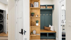 A modern laundry room with a wooden shelf, a bench, and a green storage unit. - Fully Updated 2 Bedroom Apartment - In Downtown and Steps from Green Lake (Green Lake)