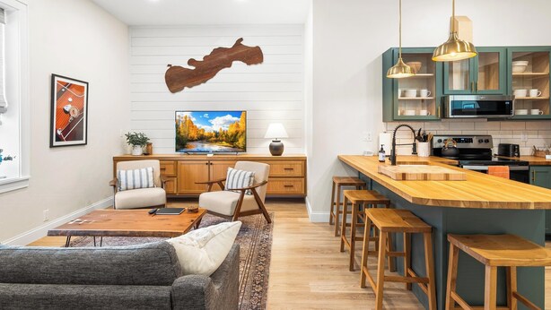 A modern kitchen with wooden cabinets, a central island, and pendant lighting. - Fully Updated 2 Bedroom Apartment - In Downtown and Steps from Green Lake (Green Lake)