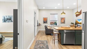A modern kitchen with a wooden countertop, stainless steel appliances, and pendant lighting. - Fully Updated 2 Bedroom Apartment - In Downtown and Steps from Green Lake (Green Lake)