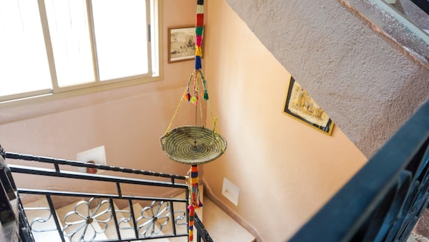 A staircase with a metal railing and a hanging decorative item. - Auberge de la jeunesse d ouarzazate  (Tarmigt)