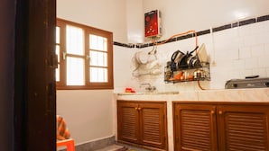 A kitchen with a window, a dish rack, a sink, and cabinets. - Auberge de la jeunesse d ouarzazate  (Tarmigt)