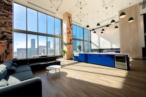 A modern office space with a large window, a blue counter, and a seating area. - Brickell Area| Free Parking| Balcony| Rooftop Pool (Miami)