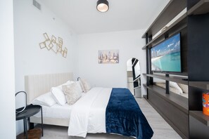 Ein modernes Schlafzimmer mit einem Bett, einem Fernseher und einem Stadtbild.