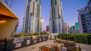Terraza en la azotea con mobiliario exterior y vistas a edificios altos.