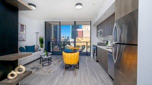 Un apartamento moderno con cocina, comedor y balcón con vistas a la ciudad.
