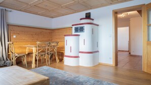 A room with a wooden ceiling, a dining table with chairs, and a large window. - ღLiboria | Aidling Panorama house with mountain view (Riegsee)