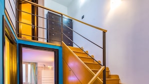 A staircase with wooden steps and metal railings leading to a second floor. - Casa al rettifilo con Terrazzo (Naples)