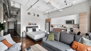 Une chambre d’hôtel moderne équipée d’un lit, d’un canapé et d’une kitchenette.