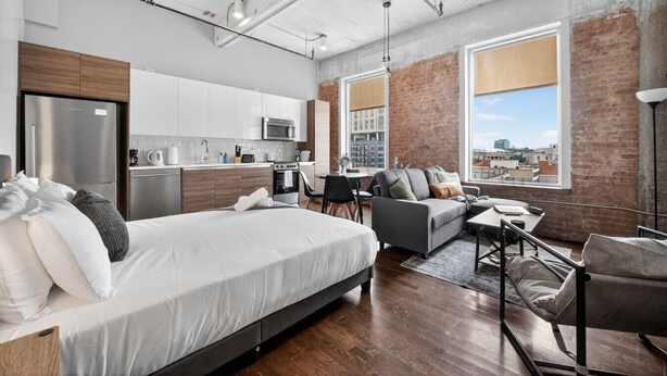 Un appartement moderne doté d’un grand lit, d’un canapé, d’un coin repas et d’une cuisine.