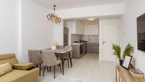 Un appartement moderne comprenant un coin repas, un canapé, une cuisine et un salon.