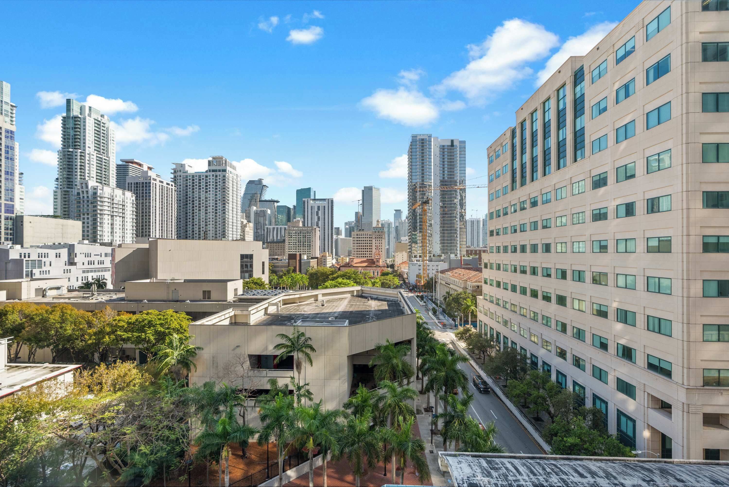 A high-rise building with a modern architectural design, featuring a prominent glass facade and a series of balconies.