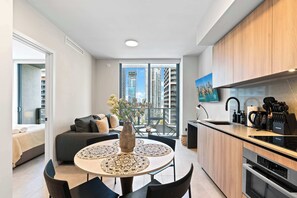 Un apartamento moderno con comedor, cocina y balcón con vistas a la ciudad.