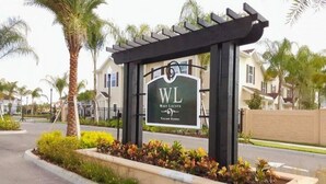 Placa do West Lucaya Village Resort com estrutura de pérgola e jardim ajardinado.