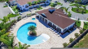 Vista aérea de um bairro residencial com piscina, casas e uma rua.