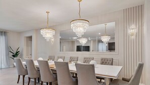 Comedor con una mesa grande, seis sillas y tres candelabros.