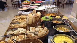 A buffet with various food items including bread, fruits, and cereals. - Hotel Blue Tree Premium by Wecare (São Paulo)