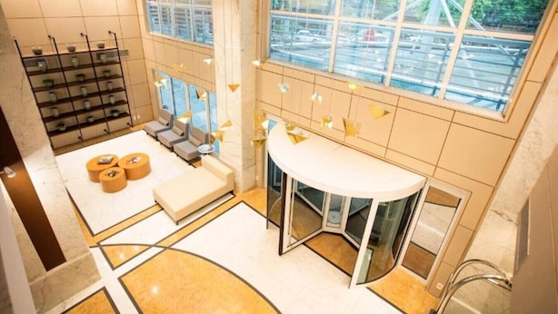 A modern bathroom with a large window, a seating area, and a vanity. - Hotel Blue Tree Premium by Wecare (São Paulo)