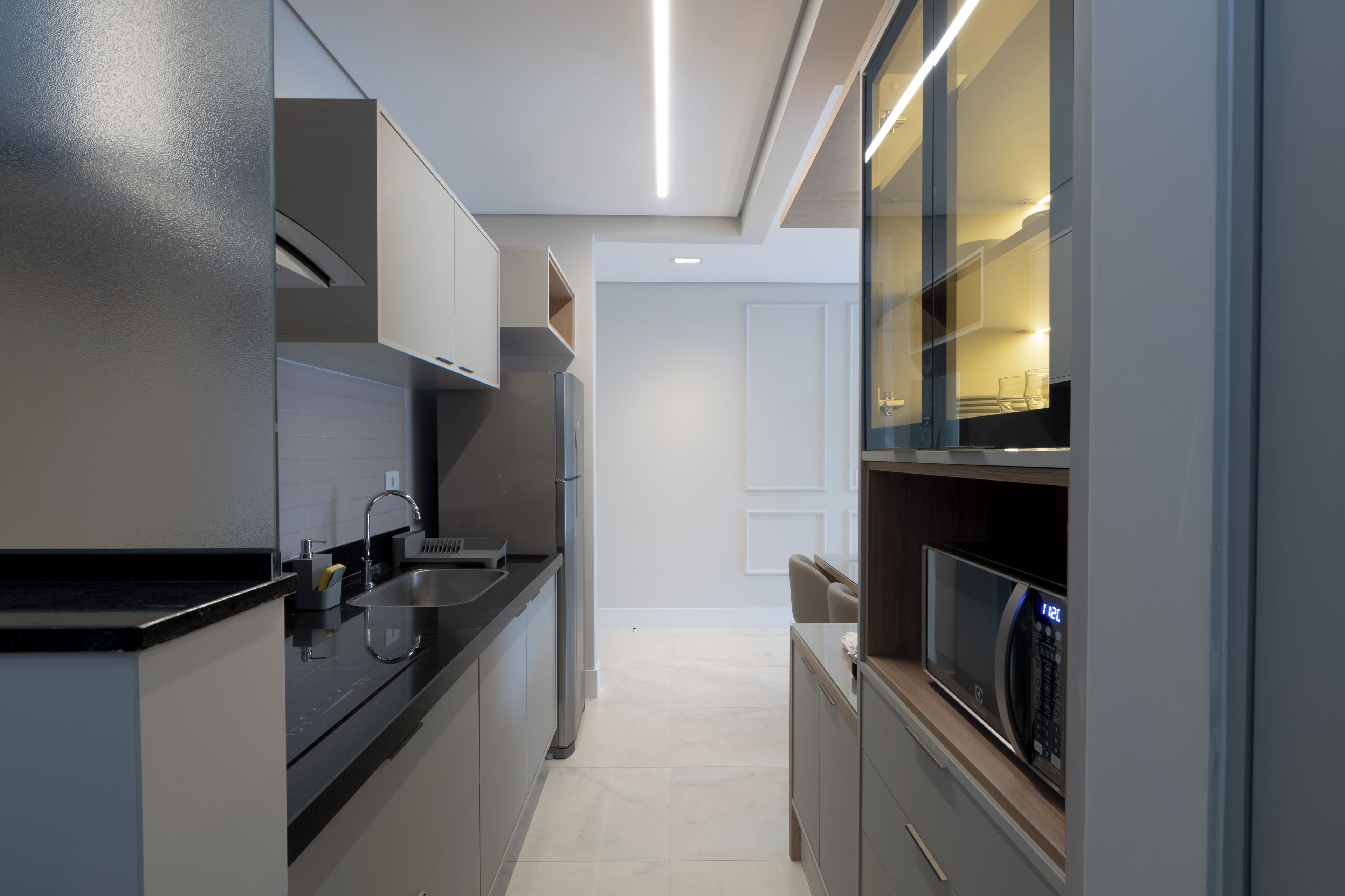 Una cocina moderna con horno empotrado, microondas y pileta.