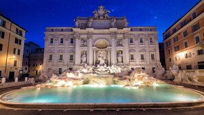 La Fontana di Trevi di notte sotto un cielo stellato.